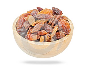 Golden dried raisins in wooden bowl isolated on white background
