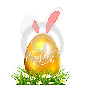 Golden Easter egg in grass with rabbit ears on white background