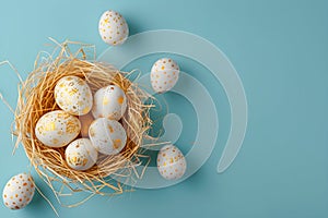 Golden Easter eggs in bird nest on pastel blue background. Happy Easter concept