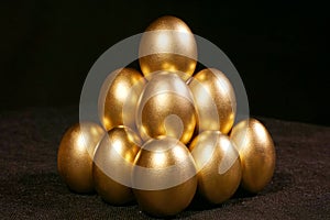 Golden eggs on black background