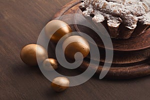 Golden eggs and easter cake on table