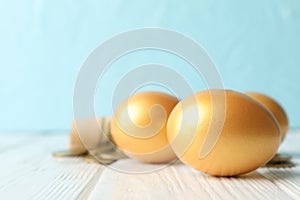 Golden eggs and money on against blue background