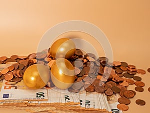 Golden eggs on money. Golden chicken eggs on euro banknotes and coins.