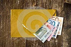 Golden envelope with Euro bills.