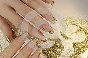 Golden fashionable French manicure on long nails