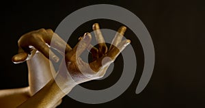 Golden female palms in black background, greasepaint on body part