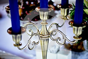The Golden five-horn candle holder with blue candle.Closely photo