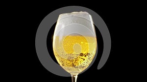 Golden foamy beer is poured slowly to the glass, beer glass in dark background, bubbles in beer, light beer
