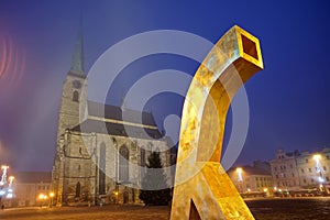 Golden fountain with a cathedral tower in the background in foggy early morning