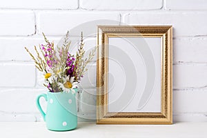 Golden frame mockup with chamomile and purple flowers in mint g