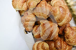 Golden fresh croissants served in wooden basket.white background