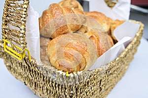 Golden fresh croissants served in wooden basket.white background