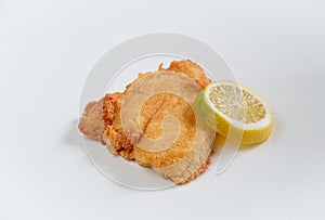 Golden fried fish plaice fillet with lemon slice on white background photo