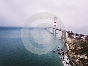 Golden Gate bridge covered in the fog under a cloudy sky in San Francisco, California