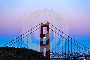 The Golden Gate Bridge highlights the full moon as seen through its north tower structure