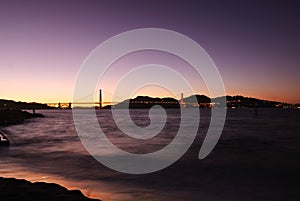 Golden Gate Bridge in magic moment at twilight time , with silky ocean