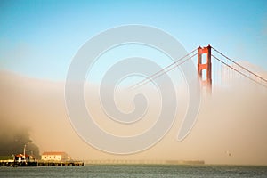 Golden Gate Bridge that rises above a sea of fog in the early morning.