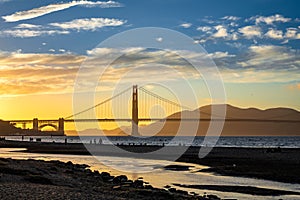 Golden gate bridge of San Francisco with river and cloudy sky at sunset