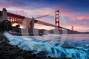 Golden Gate bridge in San Francisco at sunset with amazing seashore waves in foreground. San Francisco background. Art photograph