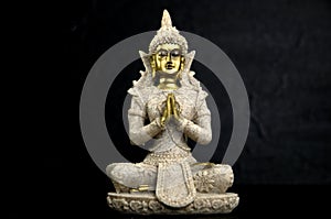 Golden Gautama Buddha with Dark Rocks Isolated on Black