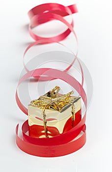 Golden gift box with a red curly ribbon.