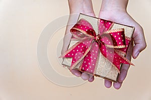 Golden gift box with red ribbow , giving gift box for special person on special day