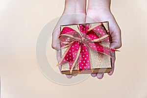 Golden gift box with red ribbow , giving gift box for special person on special day