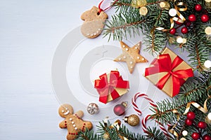 Golden gift or present boxes, fir tree branches, Christmas cookies and holiday decorations on white background top view