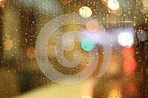 Golden glass covered with raindrops on a background of multicolored bokeh. photo