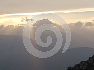 Golden glimpse of sunset, rays peeping through clouds in darjaling