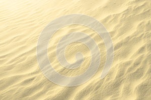 Golden glitter on blurry sand background