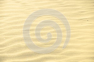Golden glitter on blurry sand background