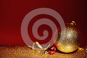 Golden glitter, Christmas balls and streamer against color background