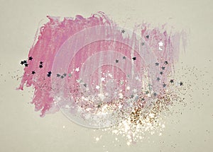 Golden glitter and glittering stars on abstract pink watercolor splash in vintage nostalgic colors
