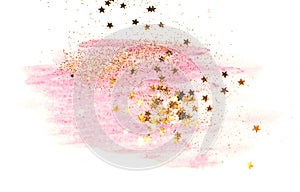 Golden glitter and glittering stars on abstract pink watercolor splash on white background