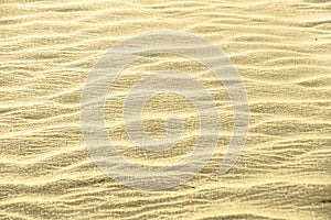 Golden glitter on sand background