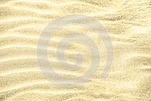 Golden glitter on sand background