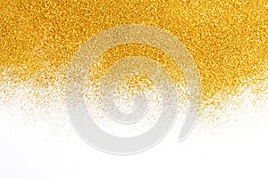 Golden glitter sand texture on white, abstract background.
