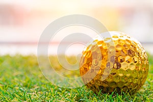 Golden golf ball on green grass with white