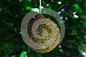 Golden green Christmas ball on a shiny green background