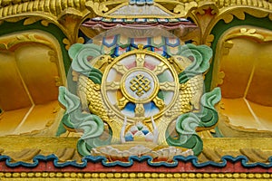 A golden green image of Tibetan Buddhist shrines on the wall of the temple