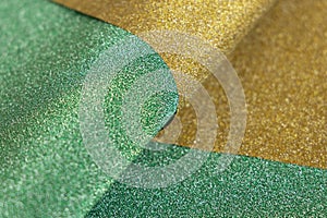 Golden and green wave shiny glitter paper texture. Shining luxurious fabric. Glimmering light green golden color