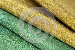 Golden and green wave shiny glitter paper texture. Shining luxurious fabric. Glimmering light green golden color