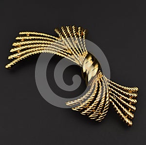 Golden hair clip isolated on black background. Fashion accessory for woman