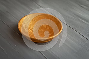 Golden handmade painted wooden plate on grey background