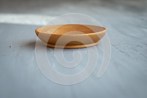 Golden handmade painted wooden plate on grey background