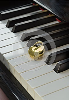 Golden heart shaped love padlock on Piano keyboard. Melody of Love