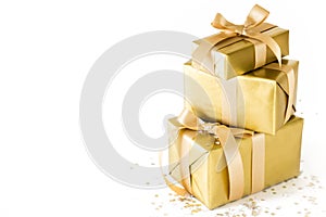 Golden holiday gifts. Gold bar. White background. Satin ribbon a