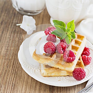 Golden homemade fresh waffles for breakfast with cream and raspberries
