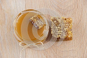 Golden honey in the comb in a jar and yellow lemon